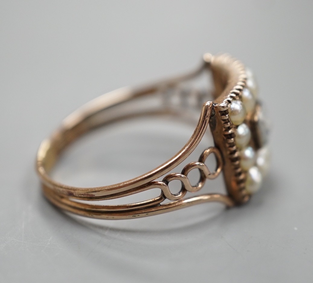 A 19th century yellow metal, split pearl and plaited hair set mourning ring, with engraved monogram beneath the ring head, size T, gross weight 2.9 grams.